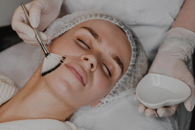 Person receiving a cosmetic procedure with gloves and tools in a clinical setting