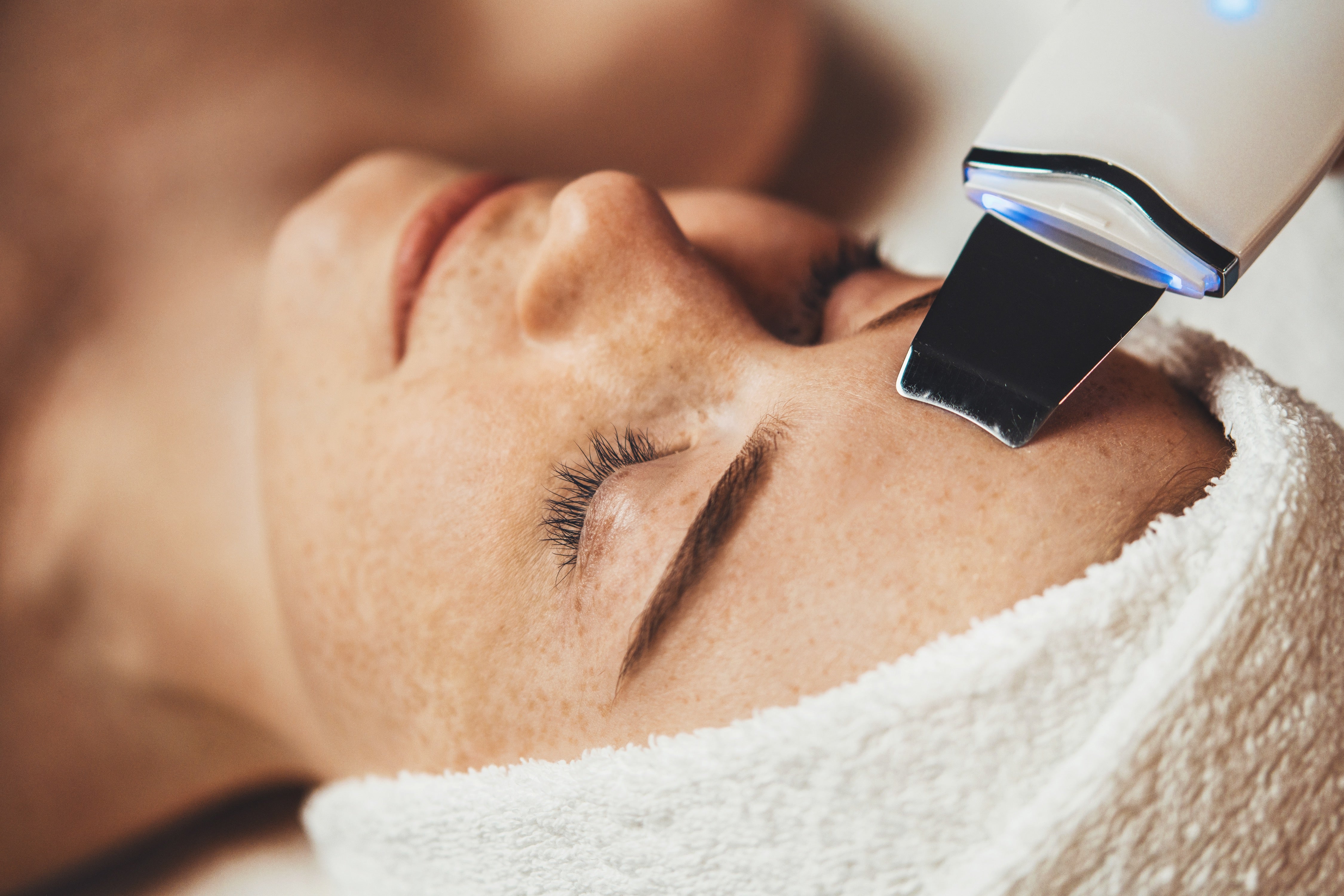 Person receiving a body peel treatment  on their face with a device