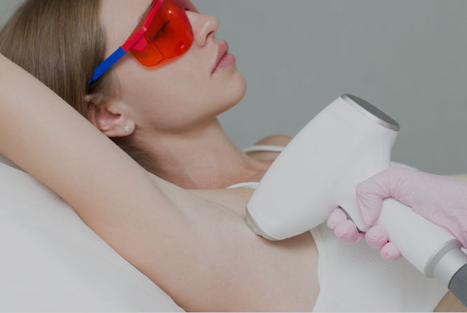 Person receiving laser hair removal treatment on underarm wearing protective goggles