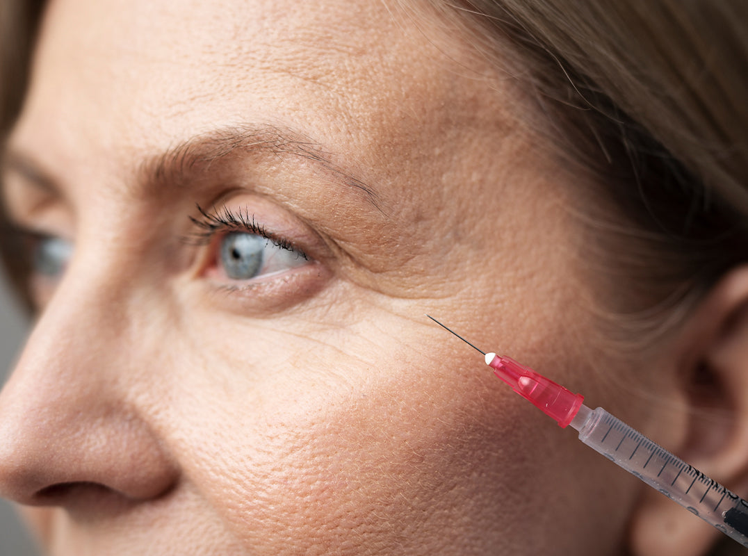 Close-up of a woman receiving a facial injection with a syringe.